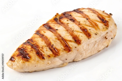 Grilled chicken breast with perfectly seared lines and seasoned edges on a plain background