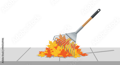 A silver metal rake with a black handle is actively raking a scattered pile of bright orange and yellow autumn leaves on a grey paved surface.