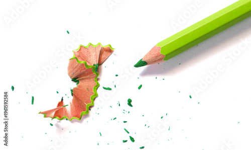 Photos Green pencil and wooden shaving on white background.