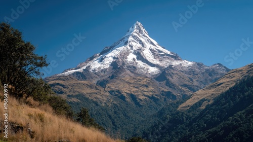 Majestic snow capped mountain peak against a clear blue sky background