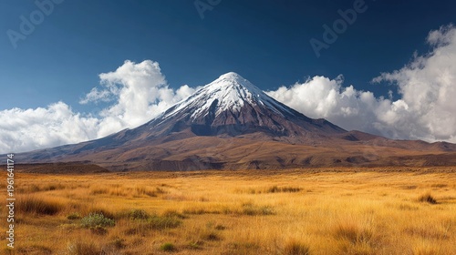Snow capped mountain landscape under blue sky with fluffy white clouds