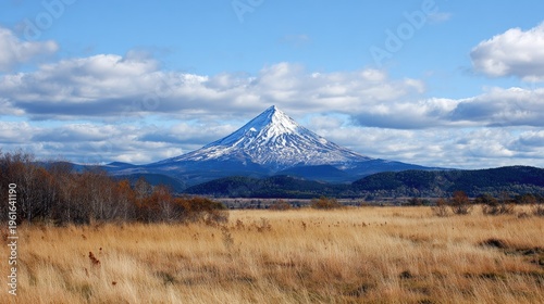 Majestic snow capped mountain landscape under a partly cloudy blue sky