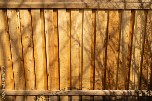 Bright Wooden Fence With Shadows From Nearby Trees During Daytime
