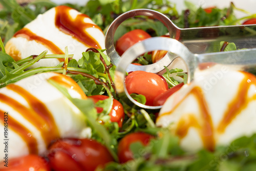 Salad With Mozzarella Cheese, Cherry Tomatoes, and Balsamic Sauce on a Plate in a Bright Setting