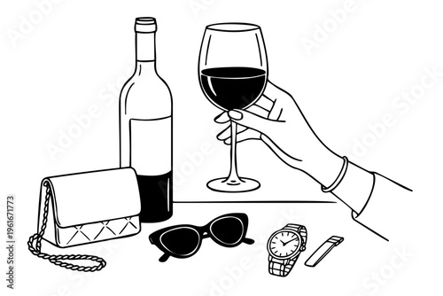Hand holding a wine glass and a bottle of wine. A watch is on the table. A handbag is on the table