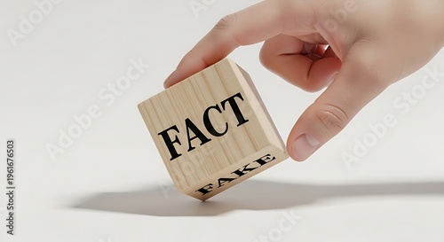 Hand flipping wooden cube with fact and fake written on it isolated on white background