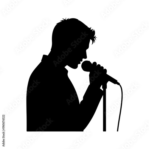Foto Silhouette of a man singing into a microphone on stage.