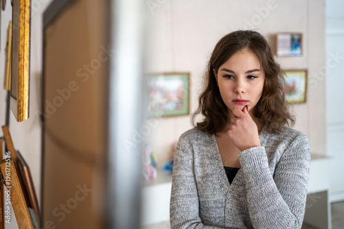 Konstfotografi young woman, alone, observes a painting attentively in an art gallery or museum, suggesting she is an art connoisseur, expert, or appraiser