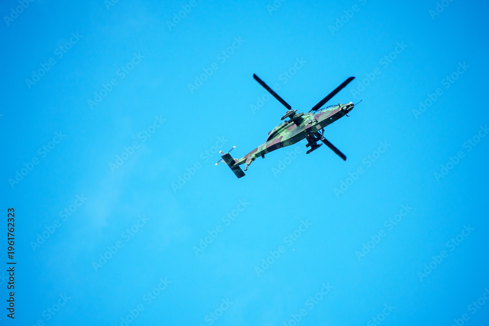 Naklejka premium Helicopter is flying on isolated blue sky in mid-air background.