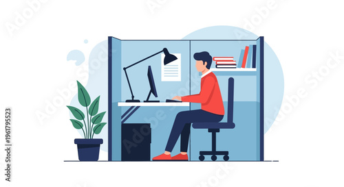 Young man working on a laptop at his desk in a modern office cubicle with a plant and books, looking focused and productive.