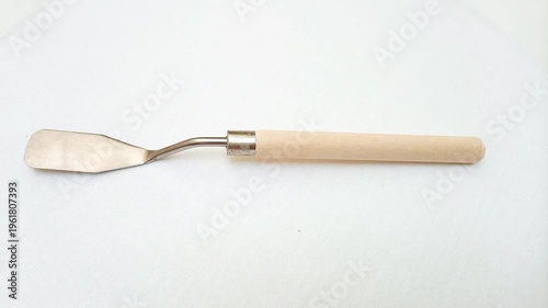 Stainless Steel Palette Knife with Wooden Handle moving on White Background, Artist Painting Tool for Acrylic and Oil Painting