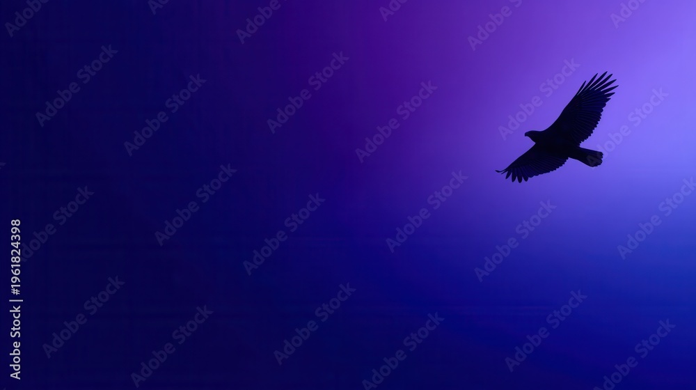 Fototapeta premium A bird soars through the vibrant purple sky with its wings spread.