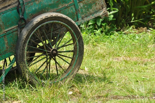 Old Rusty Cart Wheel on Grass Background