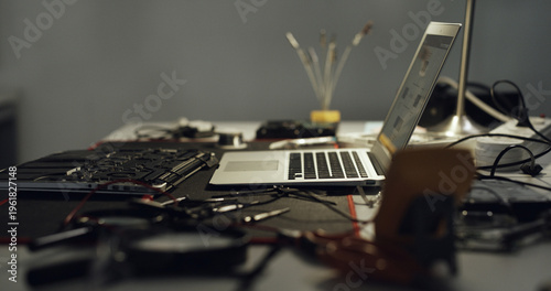 Laptop, repair and work desk with components for electronic maintenance or fix in workshop. Empty, computer or IT engineering with equipment for problem solving, troubleshooting or circuit testing