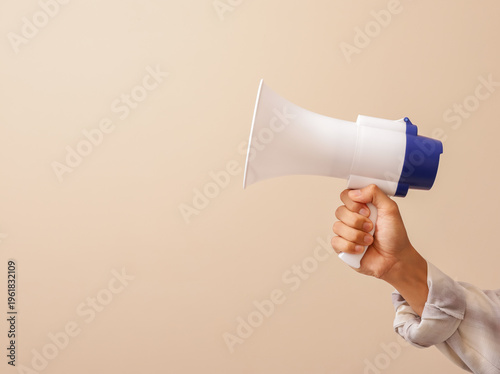 Hand holding a megaphone on a clean background, symbolizing announcement, alert, promotion, public message, and communication.