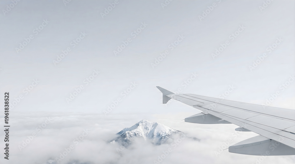 Fototapeta premium Airplane wing flying above white clouds and snow covered mountain peak