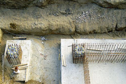 Photography Top view of foundation elements with reinforcement cages and concrete bases inside excavation