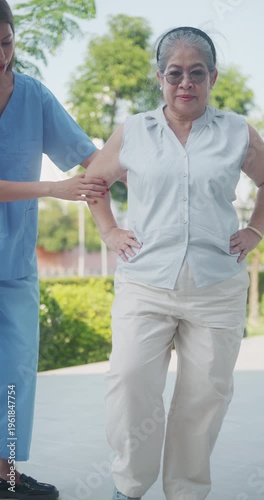 Professional physiotherapist helping a senior woman practice leg lift exercises for balance and strength.