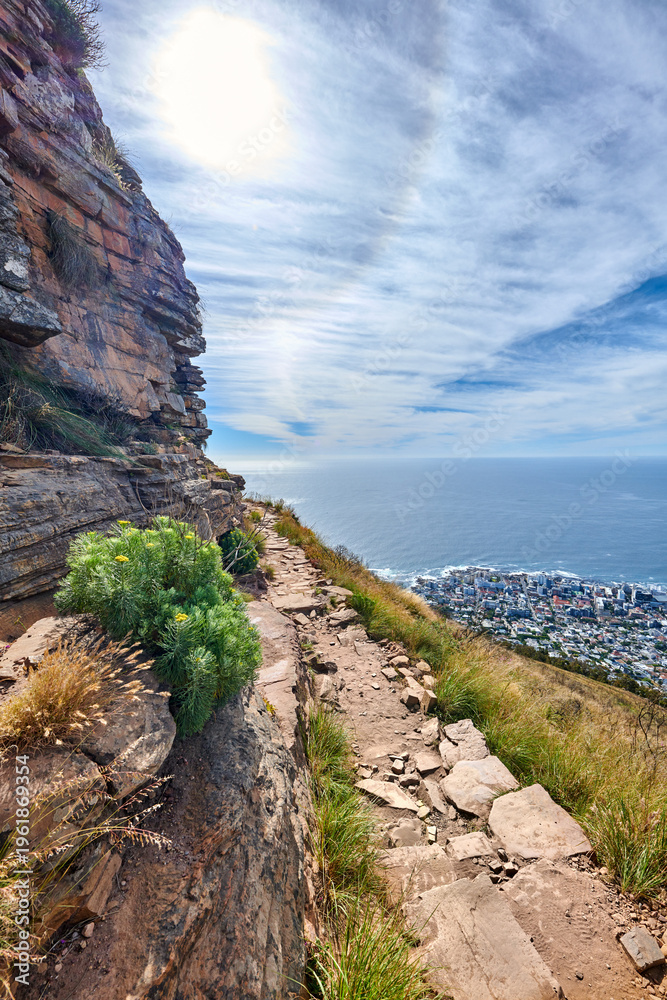 Fototapeta premium Landscape, sky and mountain with ocean in nature for travel, hiking trail and adventure. Pathway, cityscape and environment with seascape, tourism location and trekking route for holiday destination