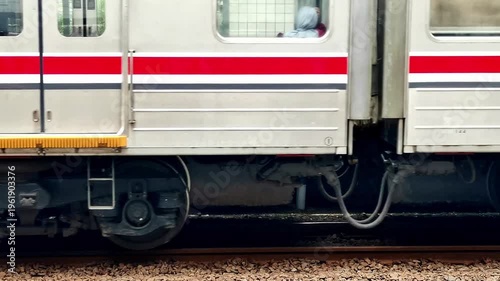 Close-up of passenger train car exterior with mechanical undercarriage and safety features visible