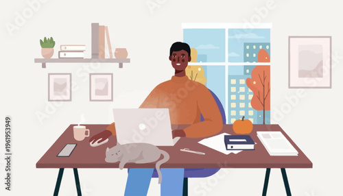 Happy African American man working productively from his home office, enjoying a cozy autumn atmosphere with his cat by his side, using a laptop