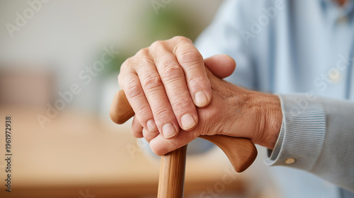 Faceless close-up of an elderly person's hands gripping a wooden walking cane with a caregiver's hand resting gently on top, bright nursing home interior, assisted living support, mobility care,