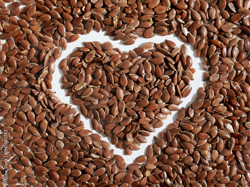 Brown flax seeds on a white background, flax seed heart