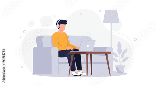 Man working on laptop with headphones on couch, modern home office setup