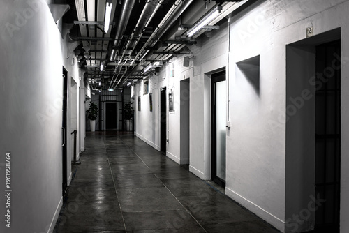Prison corridor interior at former Central Police Station Tai Kwun in Hong Kong, China, with doors, industrial pipes and perspective hallway