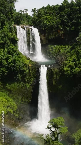 Wallpaper Mural Waterfalls with rainbow surrounded by green forest, Limunsudan Falls. Mindanao, Philippines. Vertical view. Torontodigital.ca