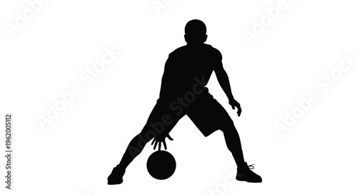 Basketball player dribbling with a ball captured in dark silhouette