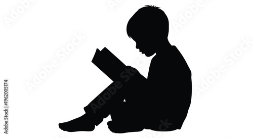 Young boy engrossed in reading a book a striking silhouette