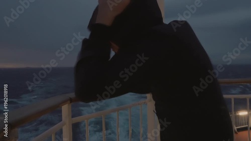 Positive young boy in a hooded jacket giving a thumbs up on the aft deck while facing a storm on the ferry from Denmark to Norway. A powerful 4K lifestyle moment of resilience and adventure at sea.
