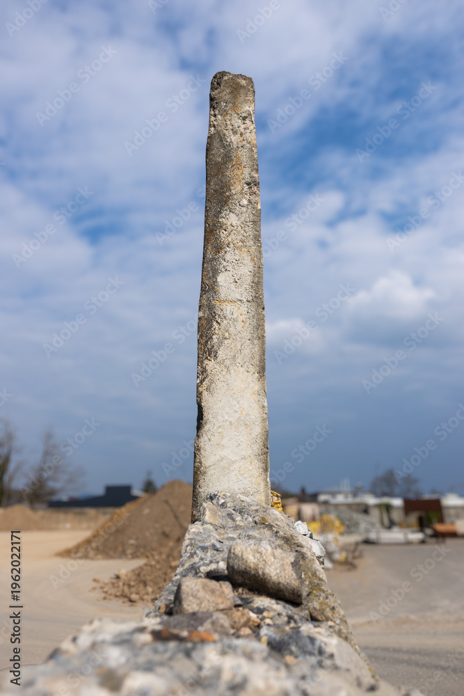 Fototapeta premium Weathered Concrete Pillar Against Cloudy Sky at Construction Site