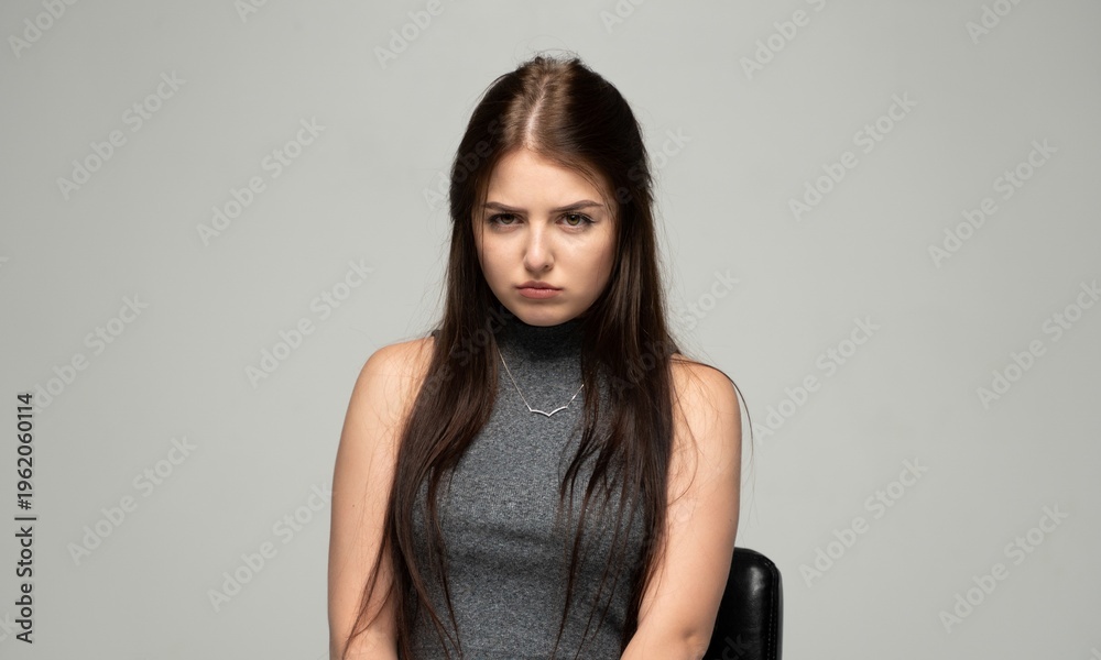Fototapeta premium Young woman showing frustration, feeling disappointment, looking upset and annoyed with a sad frown