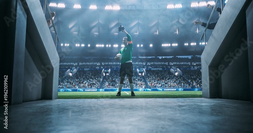 White Male Soccer Goalkeeper Waves to Fans Walks From the Stadium Tunnel Onto the Pitch With the Match Game Ball Before an International Football Final.  Professional World Cup.
