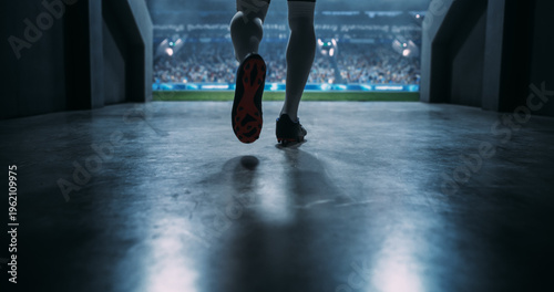 Low-angle View of a Male Soccer Player Striding Through the Stadium Tunnel Toward the Pitch Before an International Football Cinematic Style and Scale of Professionalism of a World Event.