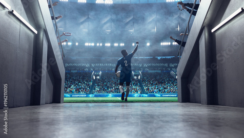 Slika na platnu Black Male Soccer Player Runs From the Tunnel Onto the Pitch With Ball in Hand, Raising His Arm to Supporters Before a Professional International Football Match Game in a Packed World Euro Stadium