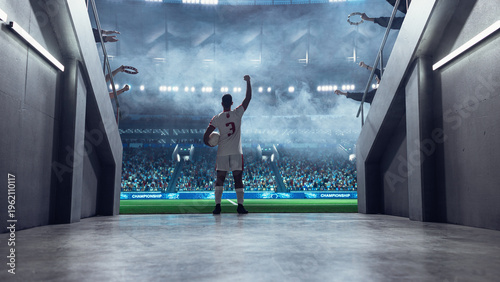Tableau sur toile Soccer Player Steps From the Stadium Tunnel Onto the Field, Ball Tucked Under Arm and Fist Raised, as Supporters Line the Entrance Before a Professional International Euro World Championship Match