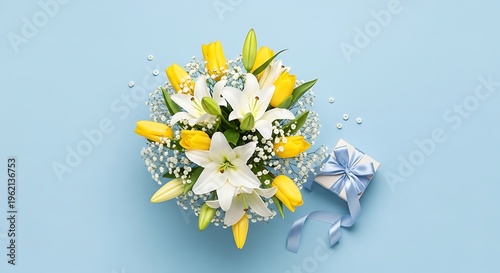 A bouquet of yellow tulips and white flowers on a light blue background