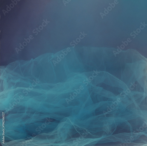 Soft blue tulle blur motion on dark background. Abstract airy cyan smoke mist fluidity overlay.