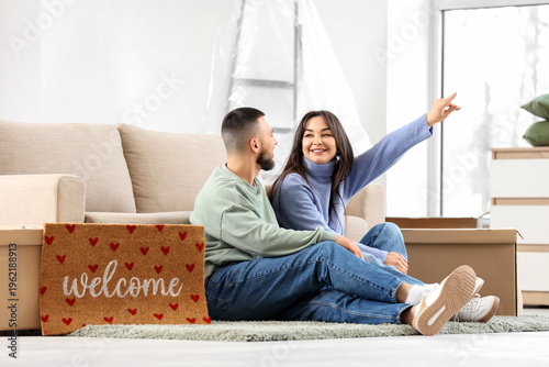 Young couple with doormat p...