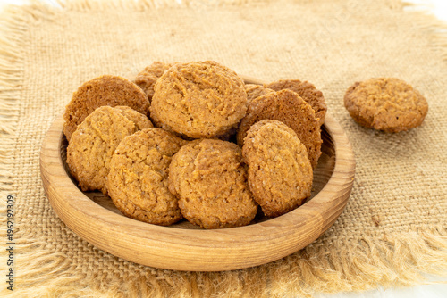 Oatmeal cookies with kitchen utensils on a jute napkin, close-up.