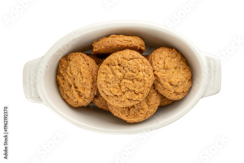 Oatmeal cookies with kitchen utensils isolated on white background, close-up.