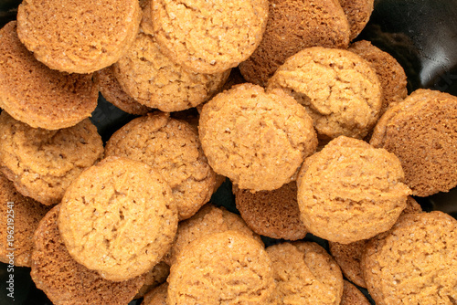 Oatmeal cookies in a black ceramic plate, close-up.