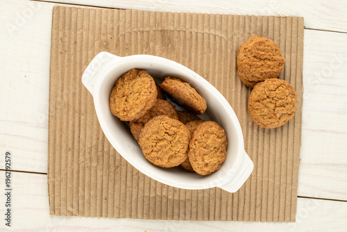 Oatmeal cookies with kitchen utensils on kraft paper, close-up. Top view.