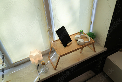 Foto Cozy bedside setup with tablet, headphones, and ambient lighting for relaxation