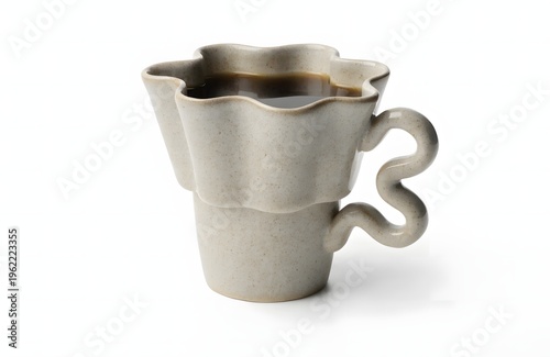 A unique ceramic coffee cup with a wavy rim and a curly handle on a white background