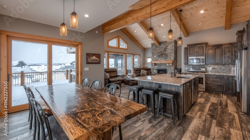 Rustic open concept living area features a large dining table and full kitchen with outdoor winter view