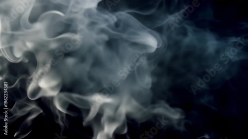 Abstract wisps of white smoke and steam rising slowly against a pure black background creating elegant organic patterns and smooth flowing movements through natural diffusion in cinematic slow motion.